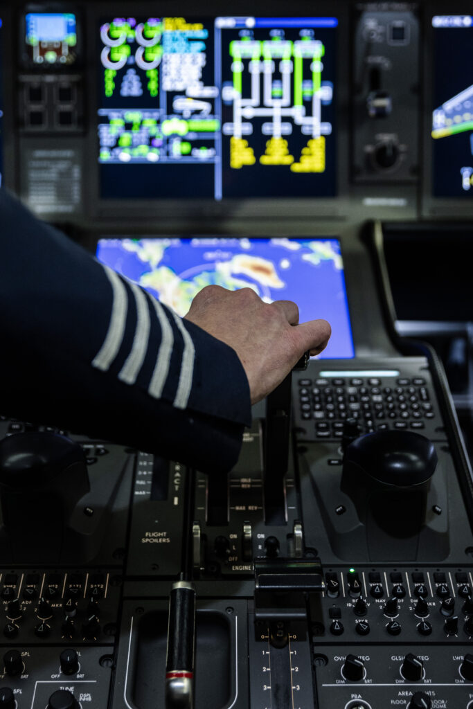 a pilot's hand operating the yoke of a private jet